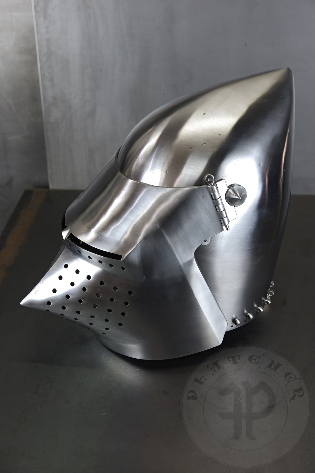 Visored bascinet based on example from Le Landeron in Switzerland, circa 1380-1400. Material: 2 mm steel with 0,3 % carbon. Heat treatment: hardened and tempered up to 34 HRC. Weight 4,090 kg / Przybica starszego typu tzw. psi pysk wzorowana na oryginale z Le Landeron w Szwajcarii, datowana na 1380-1400 rok. Materia: stal 2 mm o zawartoci wgla 0,3%. Hartowany i odpuszczany do 34 HRC. Waga 4,090 kg.